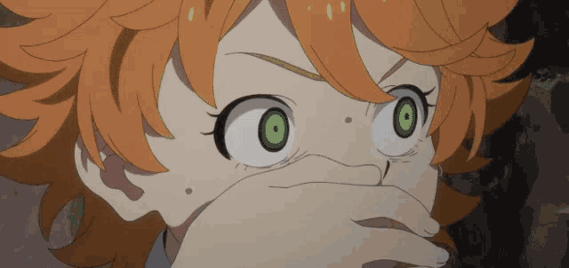 a girl with orange hair and green eyes is covering her mouth
