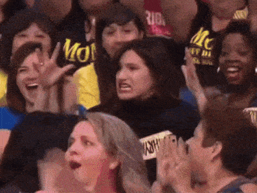 a woman in a crowd wearing a black shirt that says mc on it