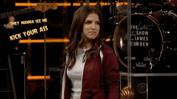 a woman stands in front of a drum set that says they wanna see me kick your ass on it