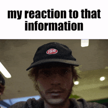 a man wearing a black iga hat stands in front of a sign that says " my reaction to that information "