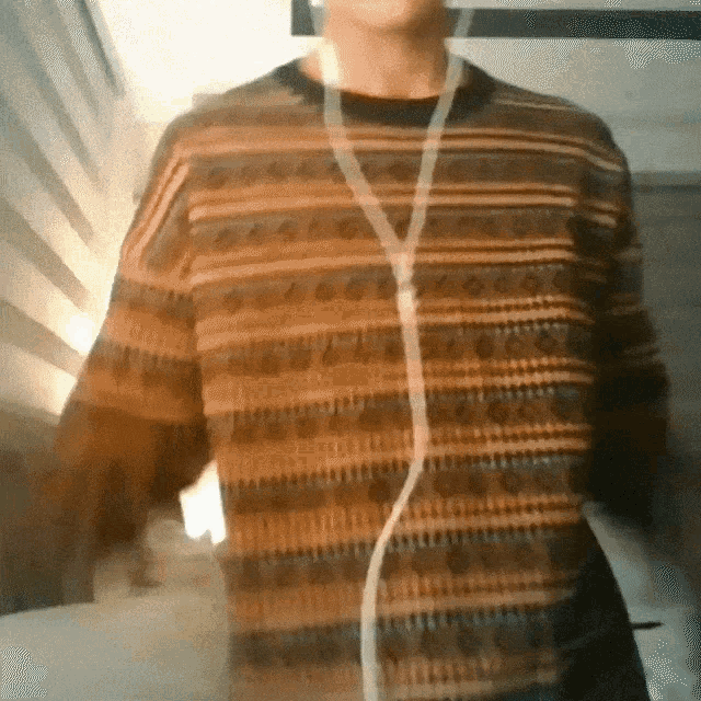 a man wearing a striped sweater and earbuds