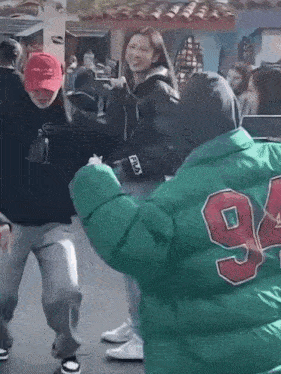 a woman wearing a red hat and a green jacket with the number 94 on it