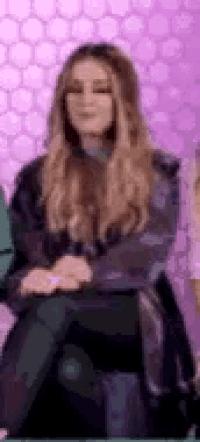 a woman is sitting in a chair with her legs crossed and looking at the camera .