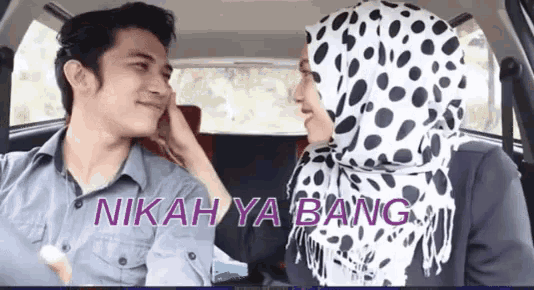 a man and a woman in a car with the words " nikah ya bang " on the bottom