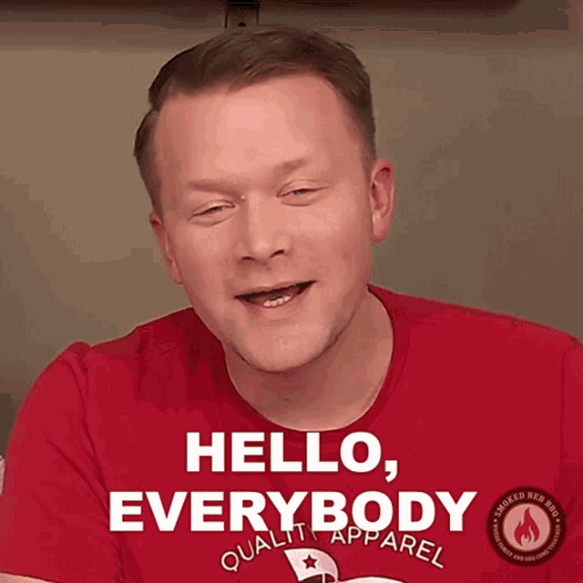 a man wearing a red shirt that says hello everybody