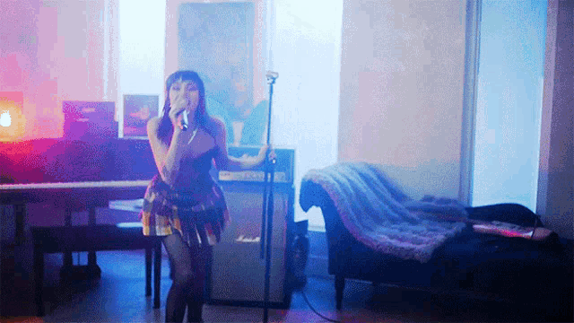 a woman is singing into a microphone in a room