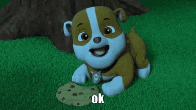 a cartoon dog is laying on the grass next to a cookie that says ok on it