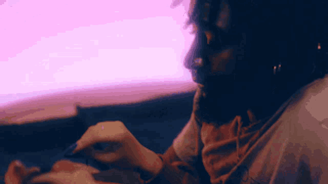 a person laying on a bed with a purple background