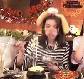 a woman wearing bunny ears is eating a bowl of food