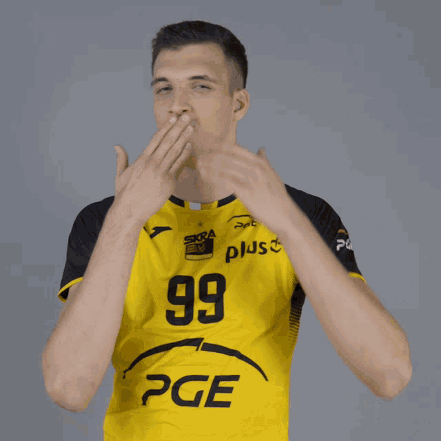a man wearing a yellow shirt with the number 99 and pge on it