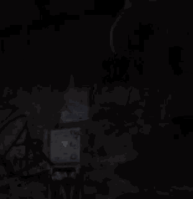 a man is standing in front of a clock in the dark