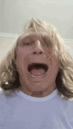 a man with long hair is sticking his tongue out
