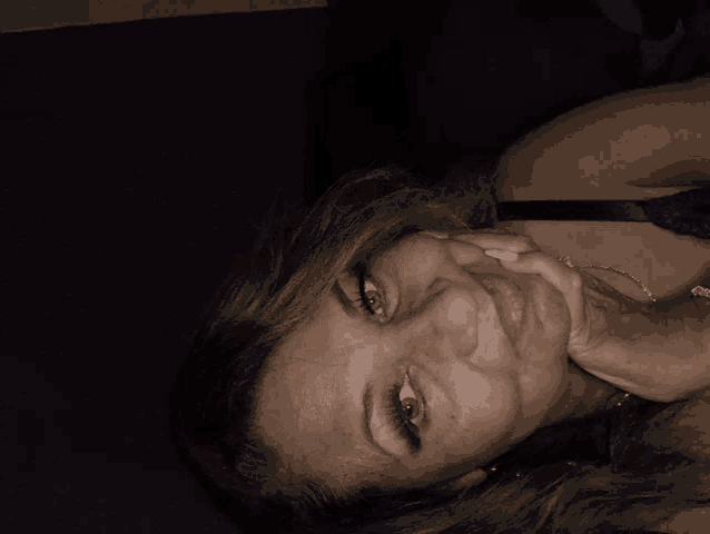 a woman is laying down with her hand on her chin