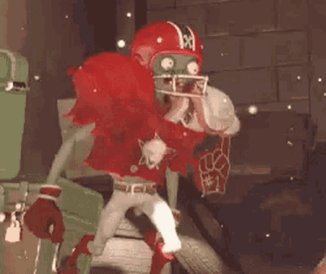 a football player in a red uniform with the number 26 on the back is running .