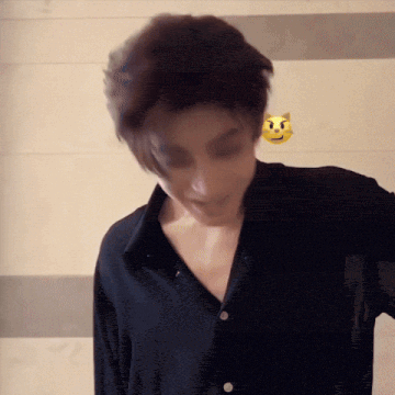 a man wearing a black shirt has a yellow smiley face on his shoulder