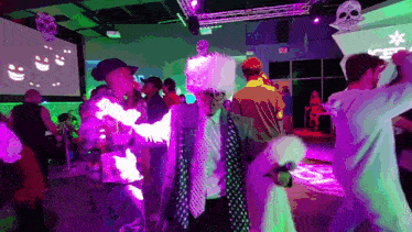 a group of people are dancing in a room with a sign that says exit on it