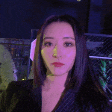 a woman with long dark hair is wearing a black striped jacket