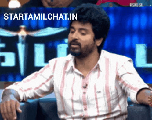 a man sitting in front of a sign that says " starttamilchat.in "