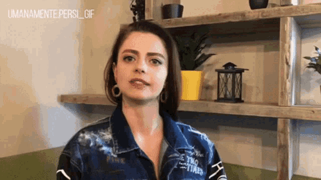 a woman wearing a denim jacket with the word pink on the front