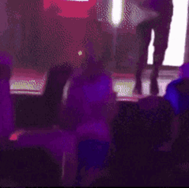 a blurry image of a person standing on a stage in front of a crowd