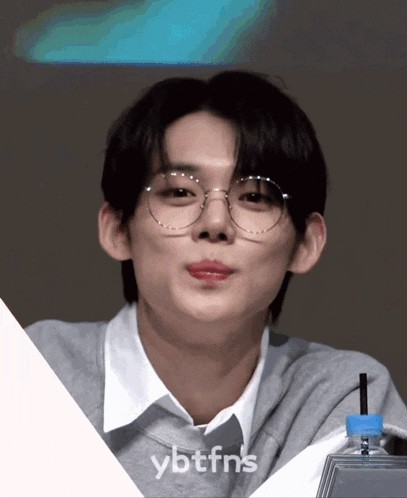 a close up of a person wearing glasses with the words ybtfns on the bottom