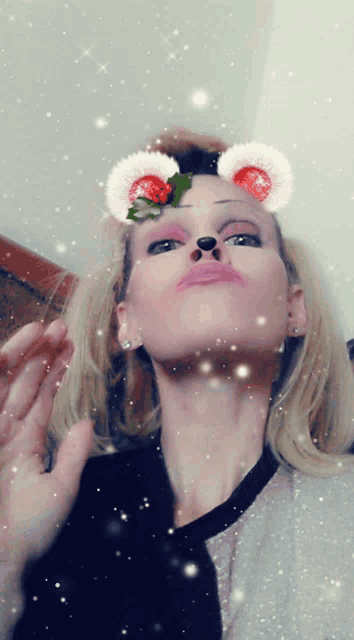 a woman wearing a christmas mask with ears and holly on her head
