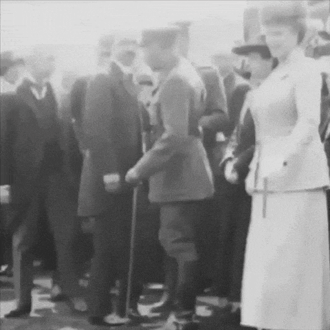 a woman in a white dress stands in a crowd of people