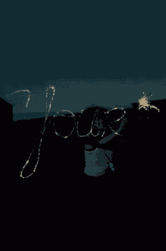 a person is holding a sparkler in front of a sign that says ' james '