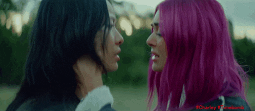 two women with pink hair are kissing each other