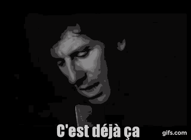 a man is singing into a microphone in a black and white photo with the words `` c ' est deja ca '' .