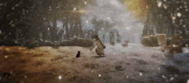 a woman kneeling down in the snow with a small black dog