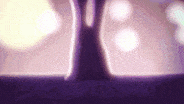 a purple lamp is sitting on a table in front of a blurred background .