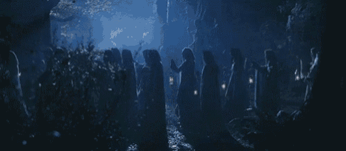 a group of ghosts are walking through a dark forest at night .