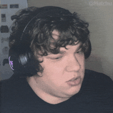 a man with curly hair wearing headphones has the hashtag @matchu on the bottom right