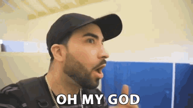 a man with a beard wearing a black hat says oh my god