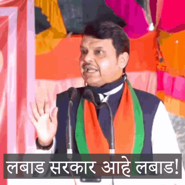 a man is giving a speech in front of microphones with a sign that says ' labad '