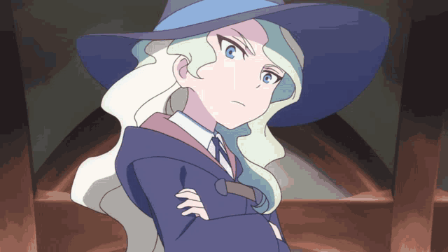 a witch with her arms crossed and a hat on