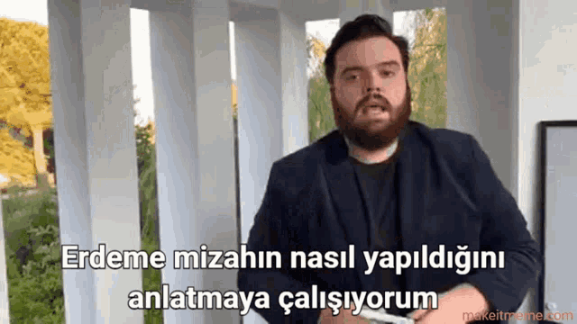 a man with a beard is standing in front of a sign that says erdeme
