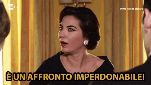 a woman in a black dress stands in front of a sign that says " un affronto imperdonabile "