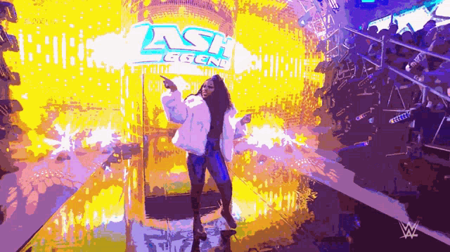 a woman stands in front of a sign that says ash legend