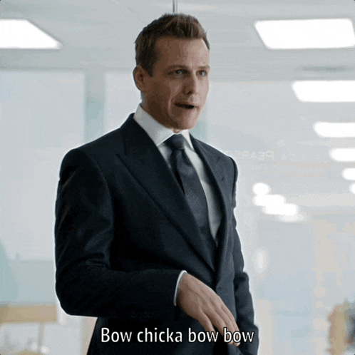 a man in a suit and tie is saying " bow chicka bow bow "