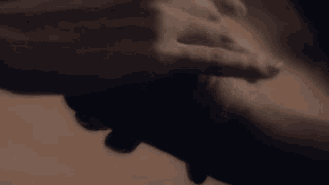 a close up of a person holding another person 's hand