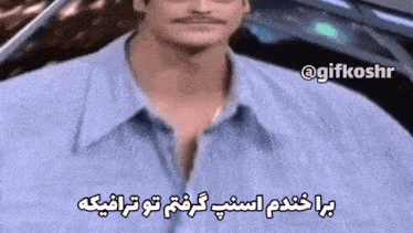 a man with a mustache is wearing a blue shirt with arabic writing on it .