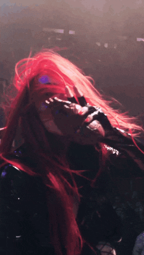 a woman with red hair sings into a microphone