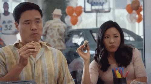 a man and a woman are sitting at a table in a restaurant eating food .