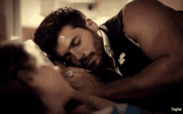 a man with a ring on his finger is sleeping on a woman 's lap
