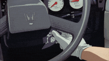 a honda steering wheel with a person 's hand pressing the start button