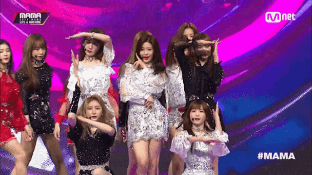 a group of girls are performing on a stage and the hashtag #mama is on the screen