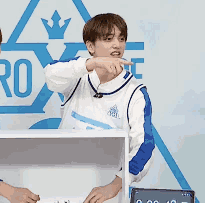 a man wearing a white and blue sweater with the word roi on the front
