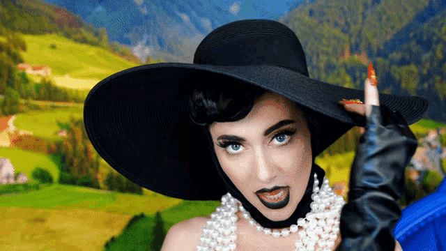a woman wearing a black hat and pearls is making a funny face